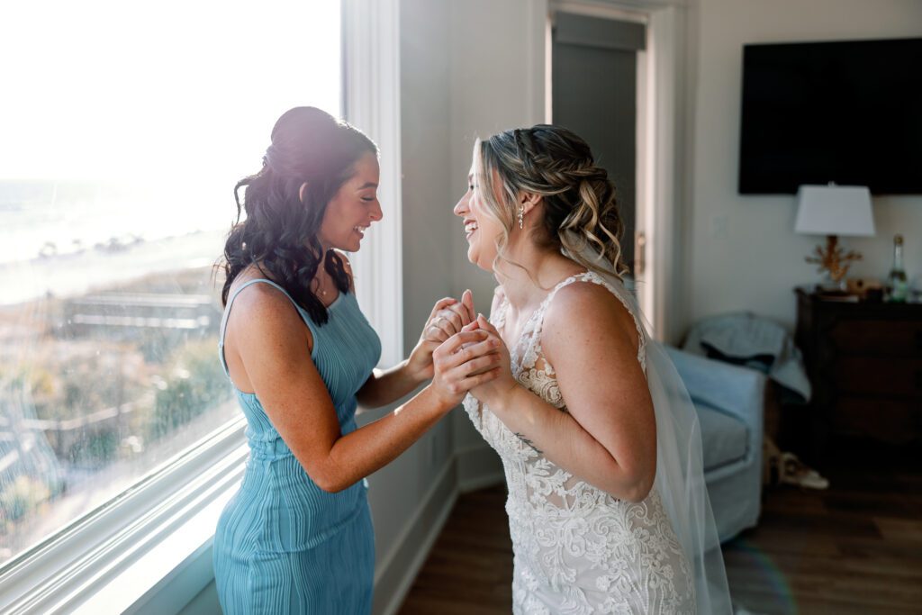 Maid of Honor and Bride laughing together in luxury beach house in Destin, FL