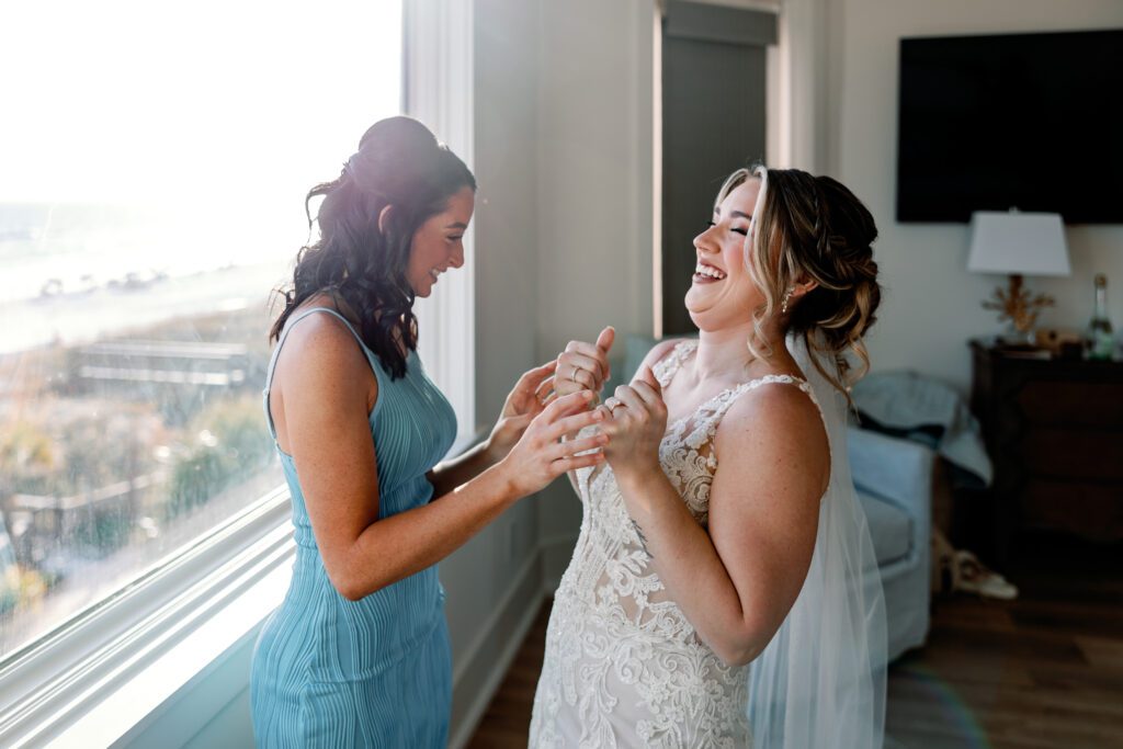Maid of Honor and Bride laughing together in luxury beach house in Destin, FL