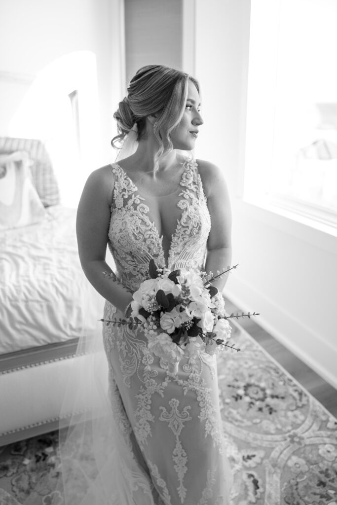 Bridal portrait with bouquet in front of large window overlooking the beach in Destin, FL