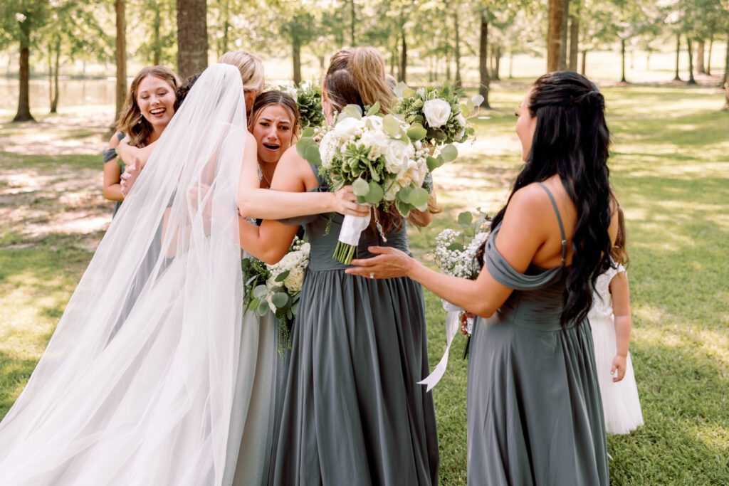 Documentary wedding photography of a bride doing an emotional and candid first look with bridesmaids at an Alabama wedding.