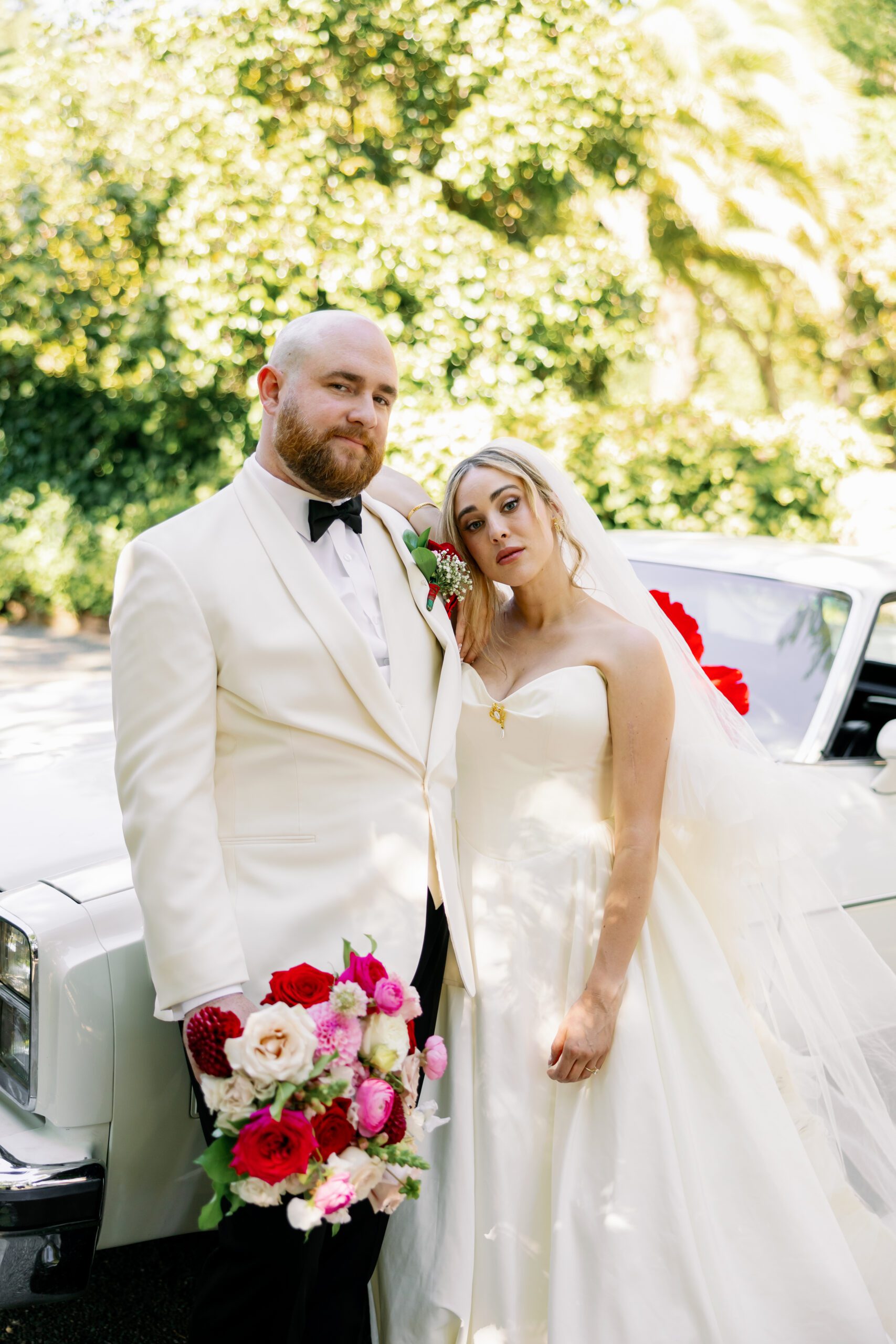 Newlyweds standing next to a vintage car at Pythian House Cottage in Santa Rosa, California